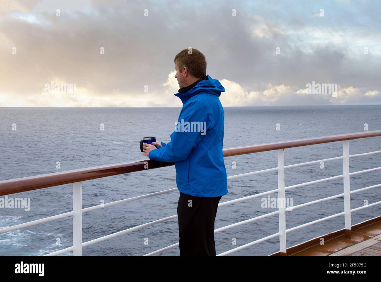 Reifer Mann, der vom Heck des Bootes hinaus ins Meer schaut Um das Wetter zu überprüfen Stockfoto