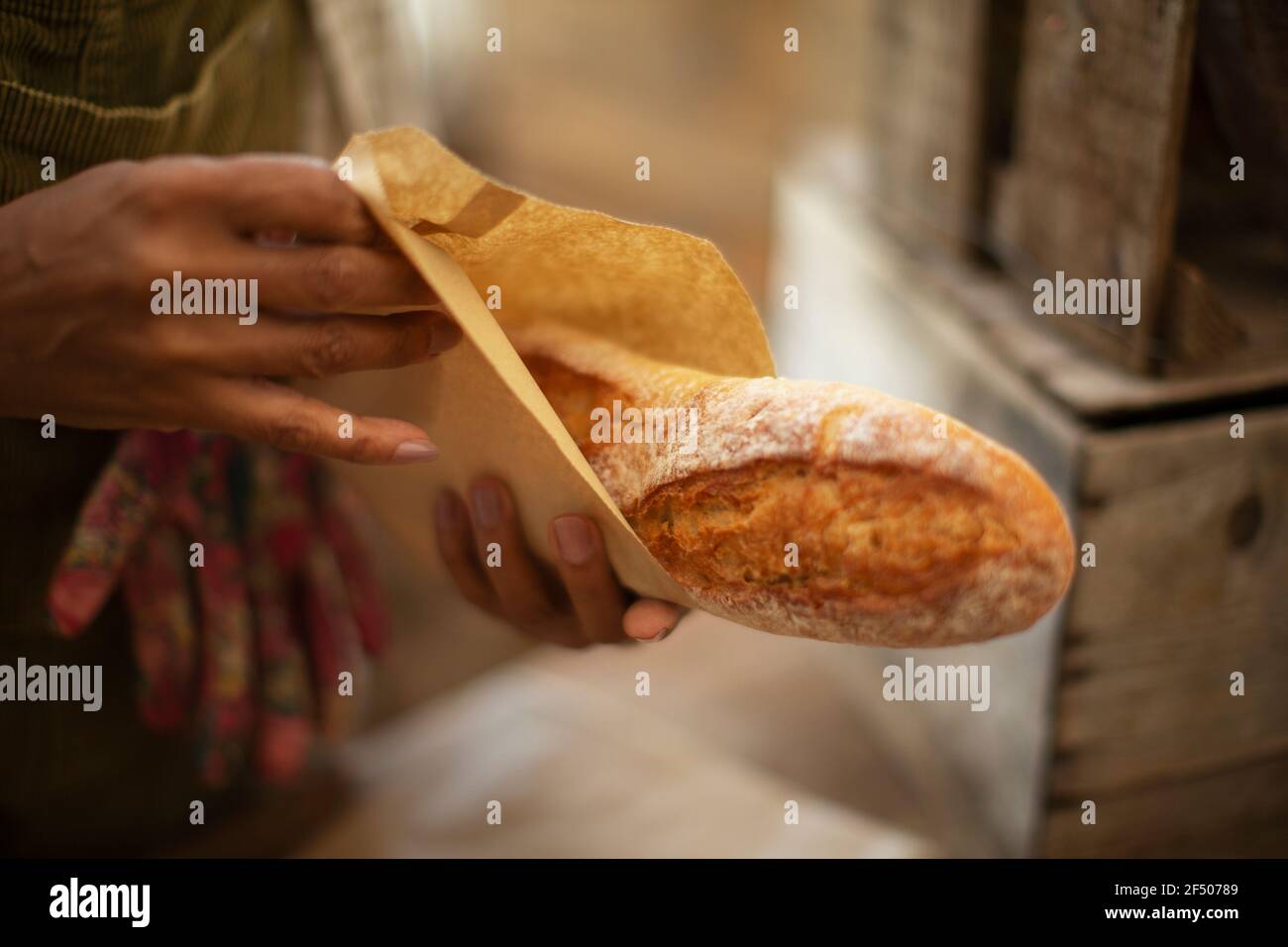 Close up weibliche Bäckerin hält frisch gebackenes Baguette Brot Stockfoto