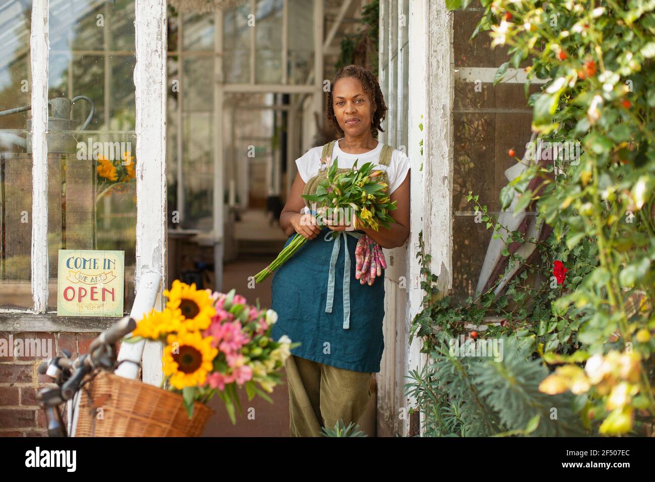 Portrait zuversichtlich weibliche Floristin mit Blumenstrauß in Shop Eingang Stockfoto