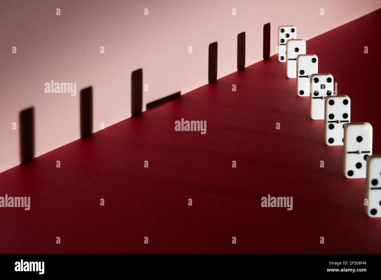 Dominosteine und Schatten soziale Distanzierung auf rotem Hintergrund Stockfoto