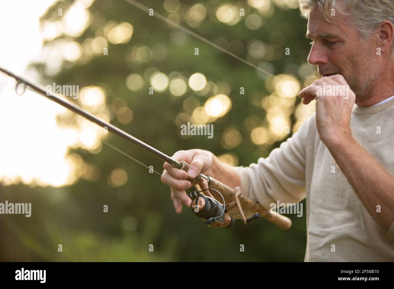 Mann, der Fliegenfischerleine vorbereitet Stockfoto