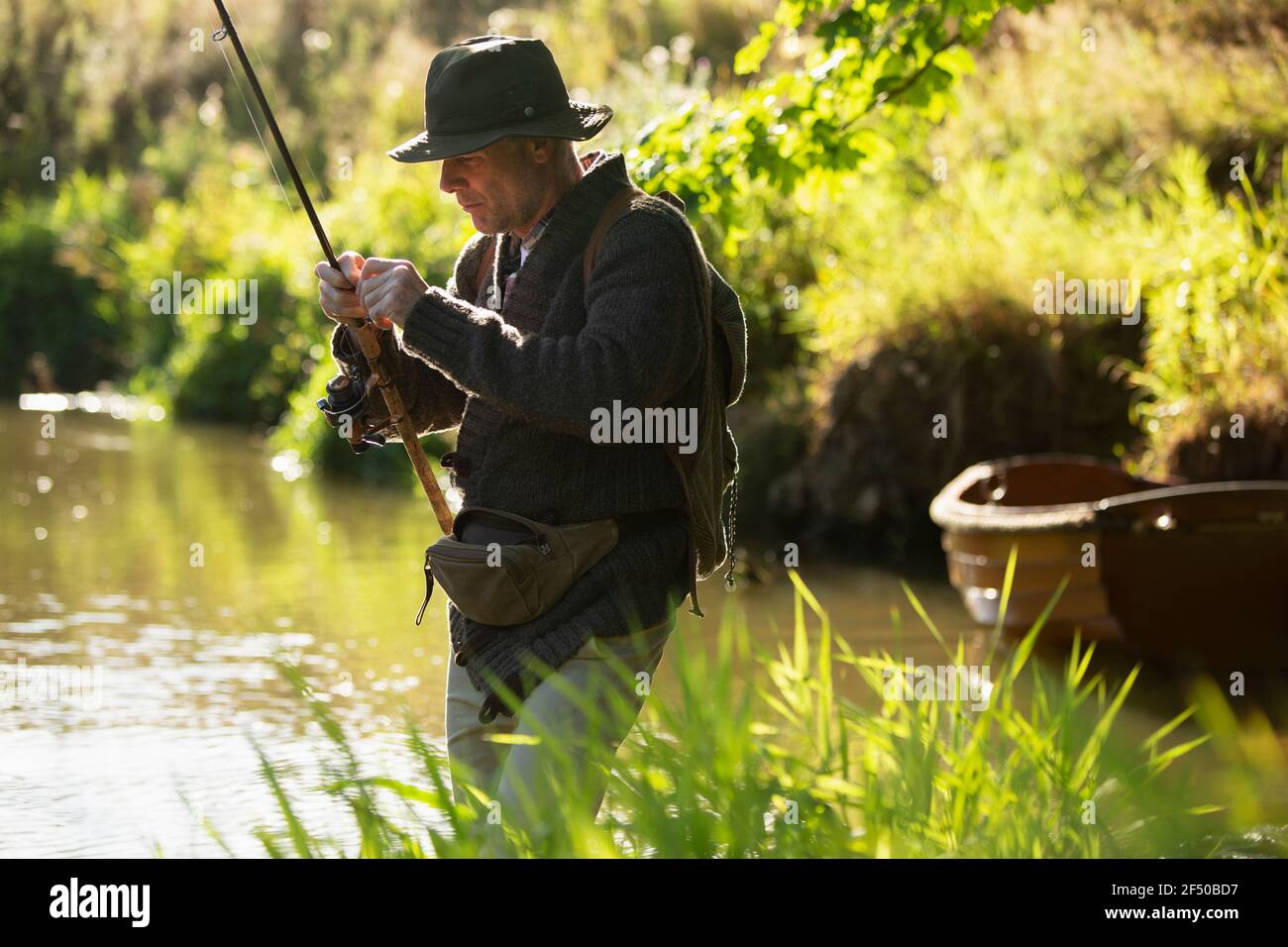 Mann Vorbereitung Fliegenfischen Linie am sonnigen Fluss Stockfoto