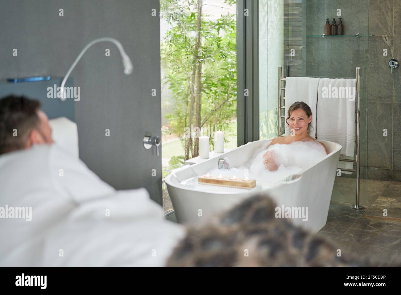 Ein glückliches Paar, das sich in einem luxuriösen Hotelzimmer mit Badewanne entspannen kann Stockfoto