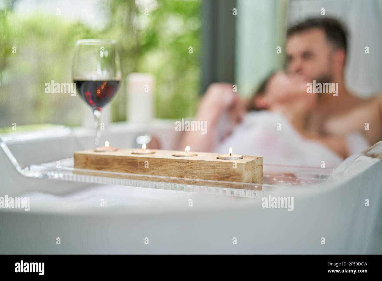 Romantisches Paar genießen Schaumbad und Wein in Badewanne Stockfoto