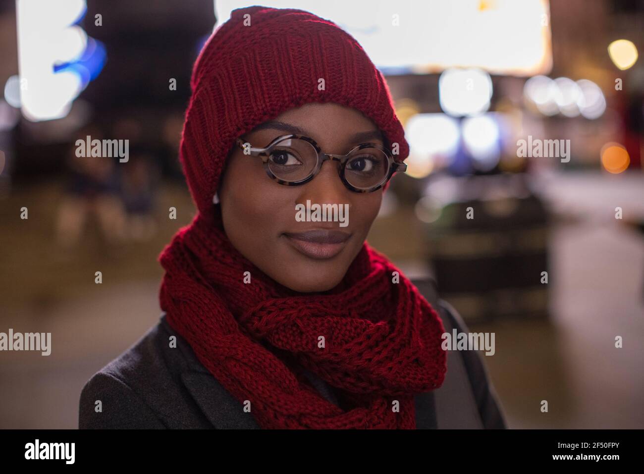 Portrait zuversichtlich junge Frau in Brillen Schal und Hut an Nacht Stockfoto