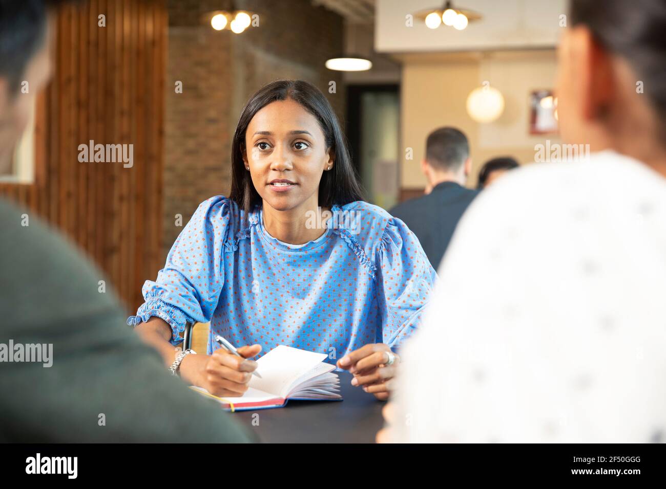 Geschäftsleute treffen sich und machen sich Notizen im Café Stockfoto