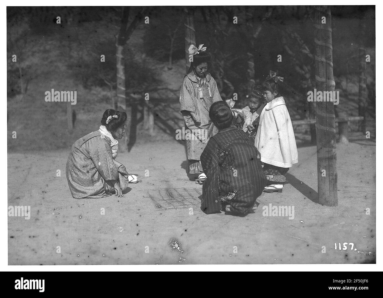Nara, Japan. Kinder spielen Kinder. Drei japanische Kinder spielen mit gezeichneten Kisten im Sand Stockfoto
