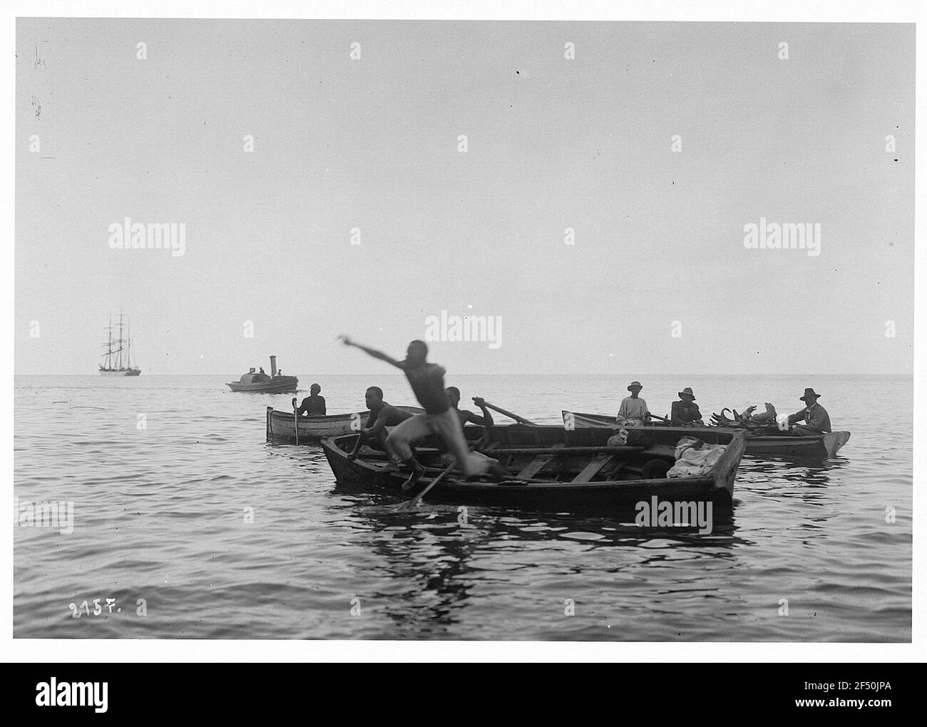 St. Thomas (Jungferninseln). Einheimische vor dem Tauchgang. Einheimische mit Touristen in Ruderbooten springt einer der Männer direkt ins Wasser Stockfoto