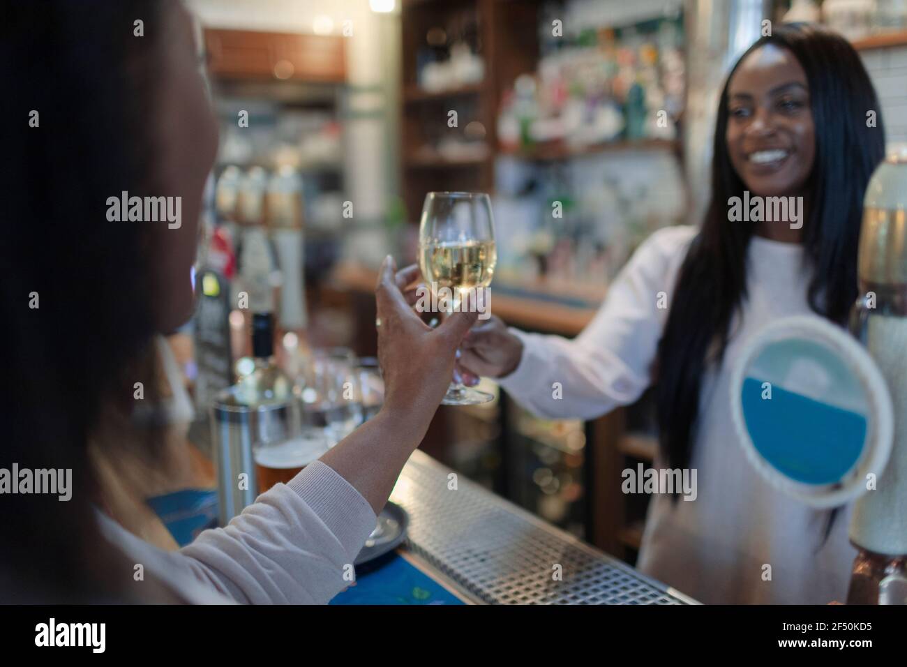 Die Barkeeperin war freundlich und servierte Frau Weißwein an der Bar Stockfoto