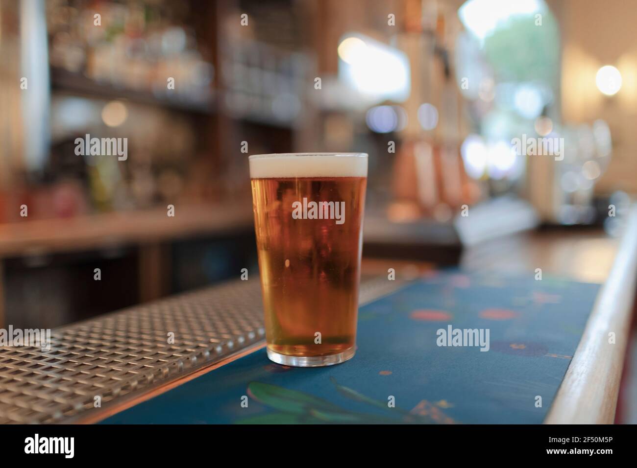 Nahaufnahme eines Pint goldenes Bier an der Kneipentheke Stockfoto