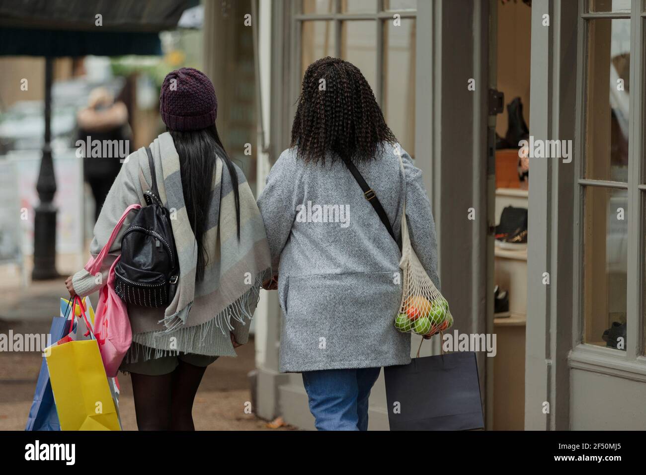 Mutter und Tochter mit Einkaufstaschen auf dem Bürgersteig Stockfoto