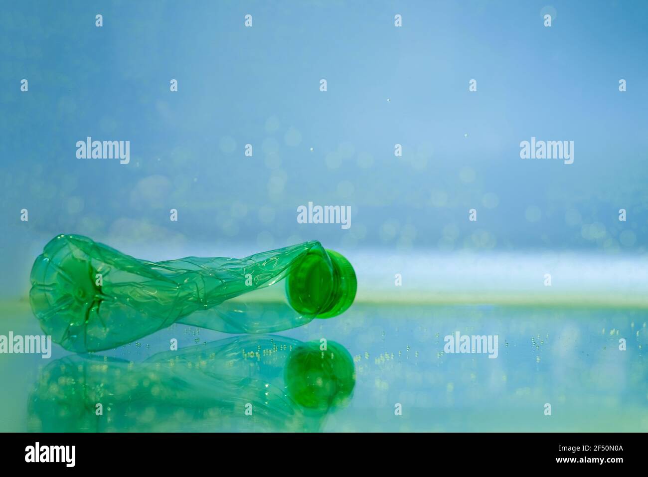 Zerknitterte Plastikflasche in Wasser, Ökologie Konzept Stockfoto