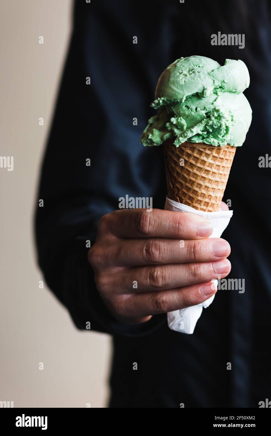 Frau hält Waffel Eis Kegel mit einer Kugel Eis gekrönt. Stockfoto
