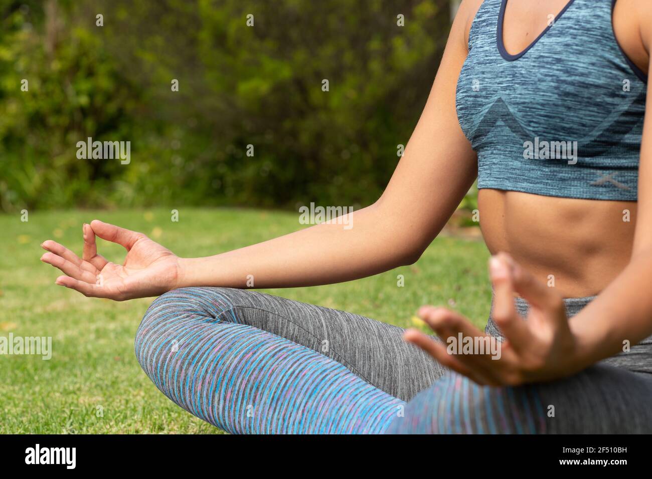 Kaukasische Frau, die mit Fingern meditiert, im Garten Stockfoto