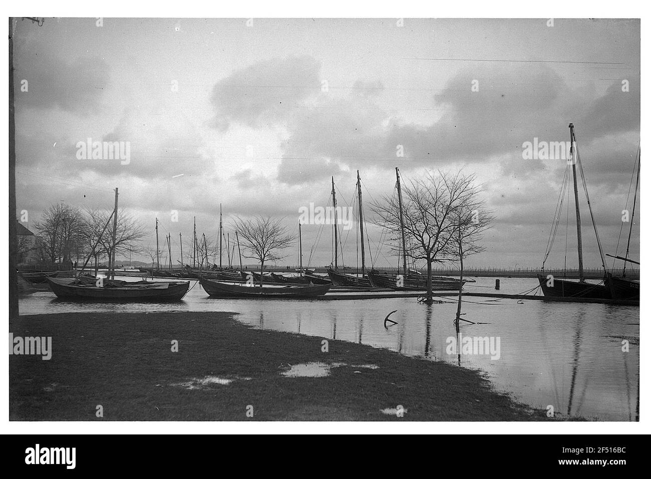 Hafen (auf einem schwimmenden Wasser?) Mit überschwemmten Wiesen. Hinter dem flachen Wasser festgemacht und verankert Segelboote Stockfoto