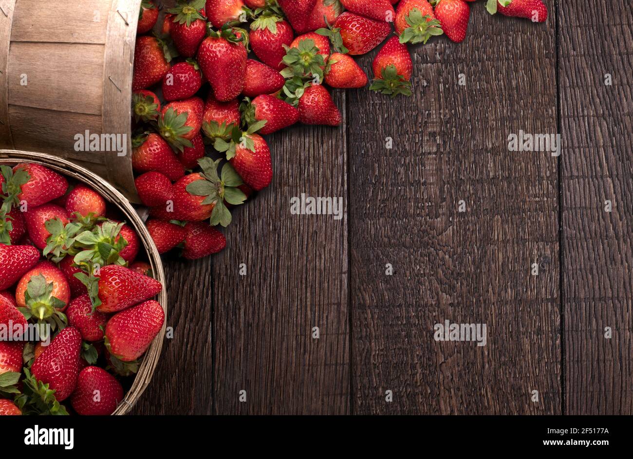Eimer mit Erdbeeren auf dem Holzboden mit Kopierplatz Stockfoto