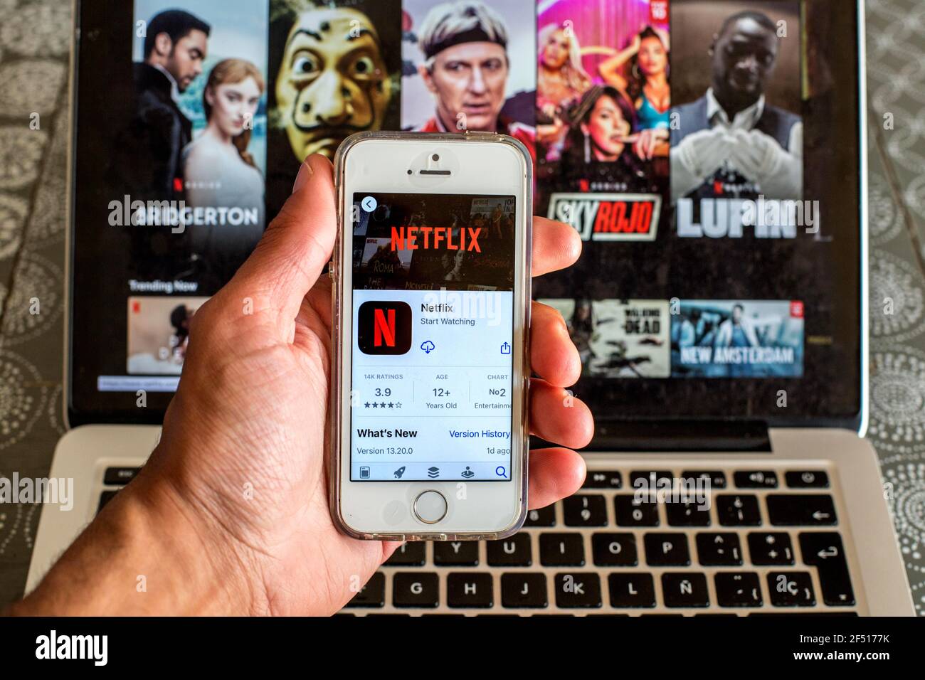 In dieser Abbildung die Netflix App im App Store Auf einem Smartphone-Bildschirm und einer Netflix-Website angezeigt Wird auf dem Laptop im Backgro angezeigt Stockfoto