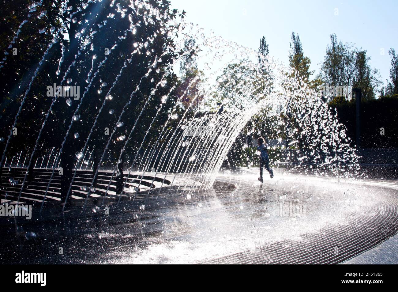 Krasnodar, Russland - 6. Oktober 2020: 'Krasnodar' Park oder 'Galitsky Park' EIN kleines Mädchen läuft fröhlich unter den Wasserbächen des Stadtbrunnens Stockfoto
