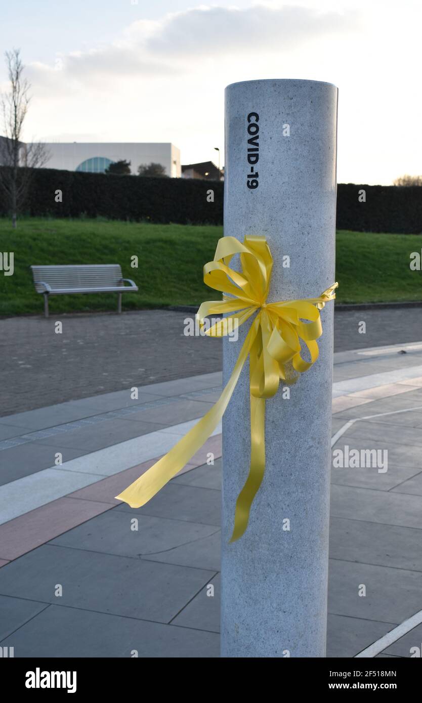 Ein gelbes Band auf der Covid-19-Säule der Milton Keynes Rose anlässlich des National Day of Reflection 2021. Stockfoto