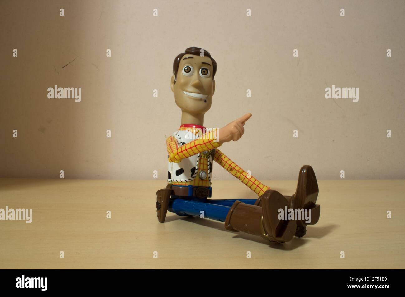 Avola, Sizilien - März 21st 2021: Nahaufnahme von Woody aus dem beliebten Actionfilm Toy Story, über einem Holztisch sitzend und lächelnd. Stockfoto