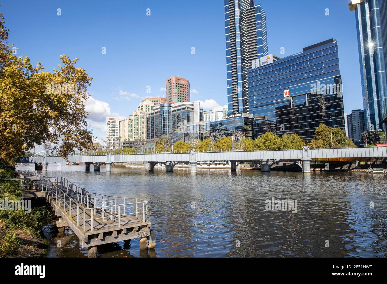 Yarra River und Melbourne City Centre Skyline mit Sandridge Immigration Bridge Crossing, eine ehemalige Zugbrücke, die heute von Fußgängern und Radfahrern genutzt wird Stockfoto