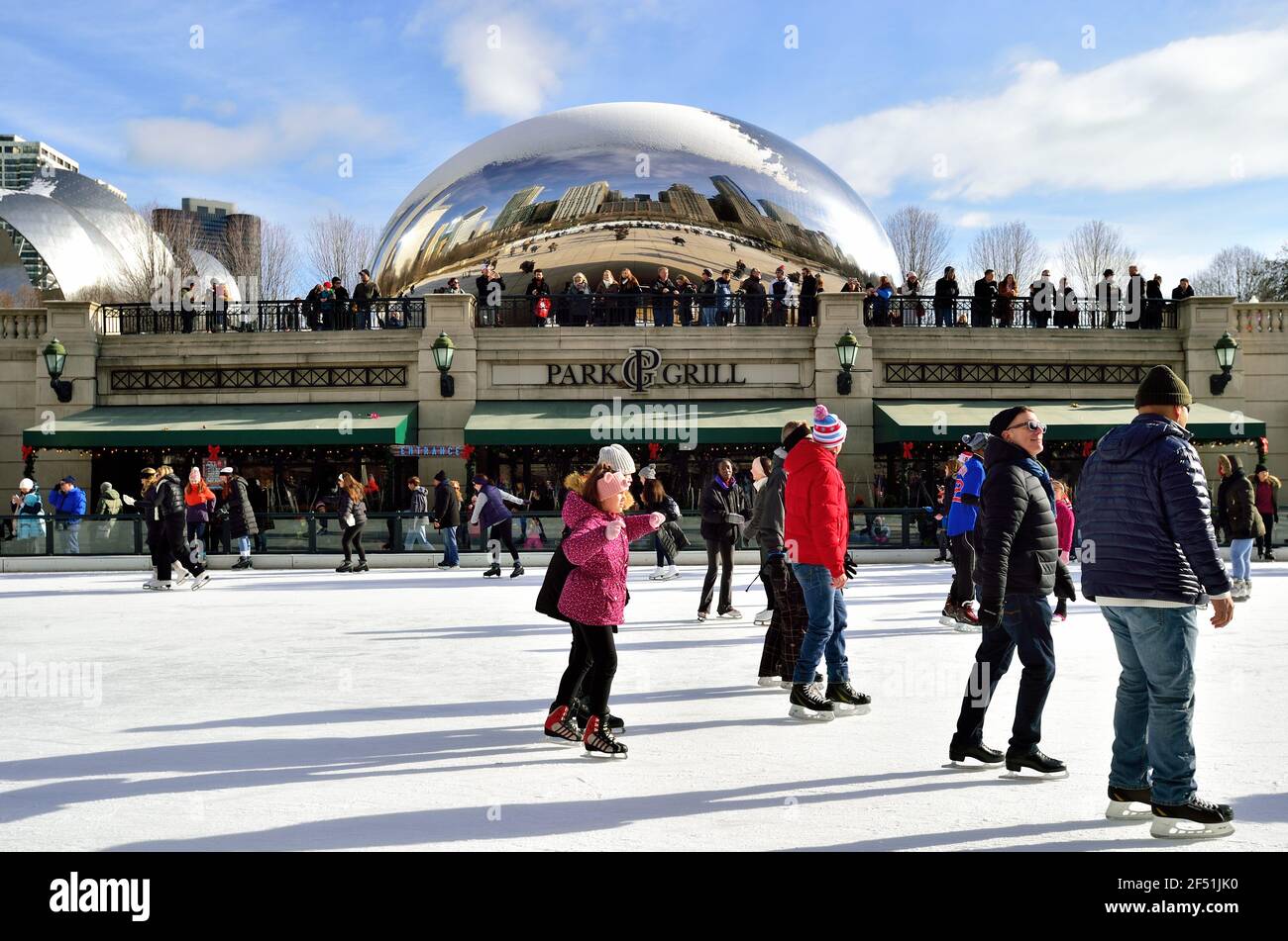 Chicago, Illinois, USA. Eisläufer auf der Eisbahn bilden den Vordergrund zum "Cloud Gate" im Millennium Park. Stockfoto