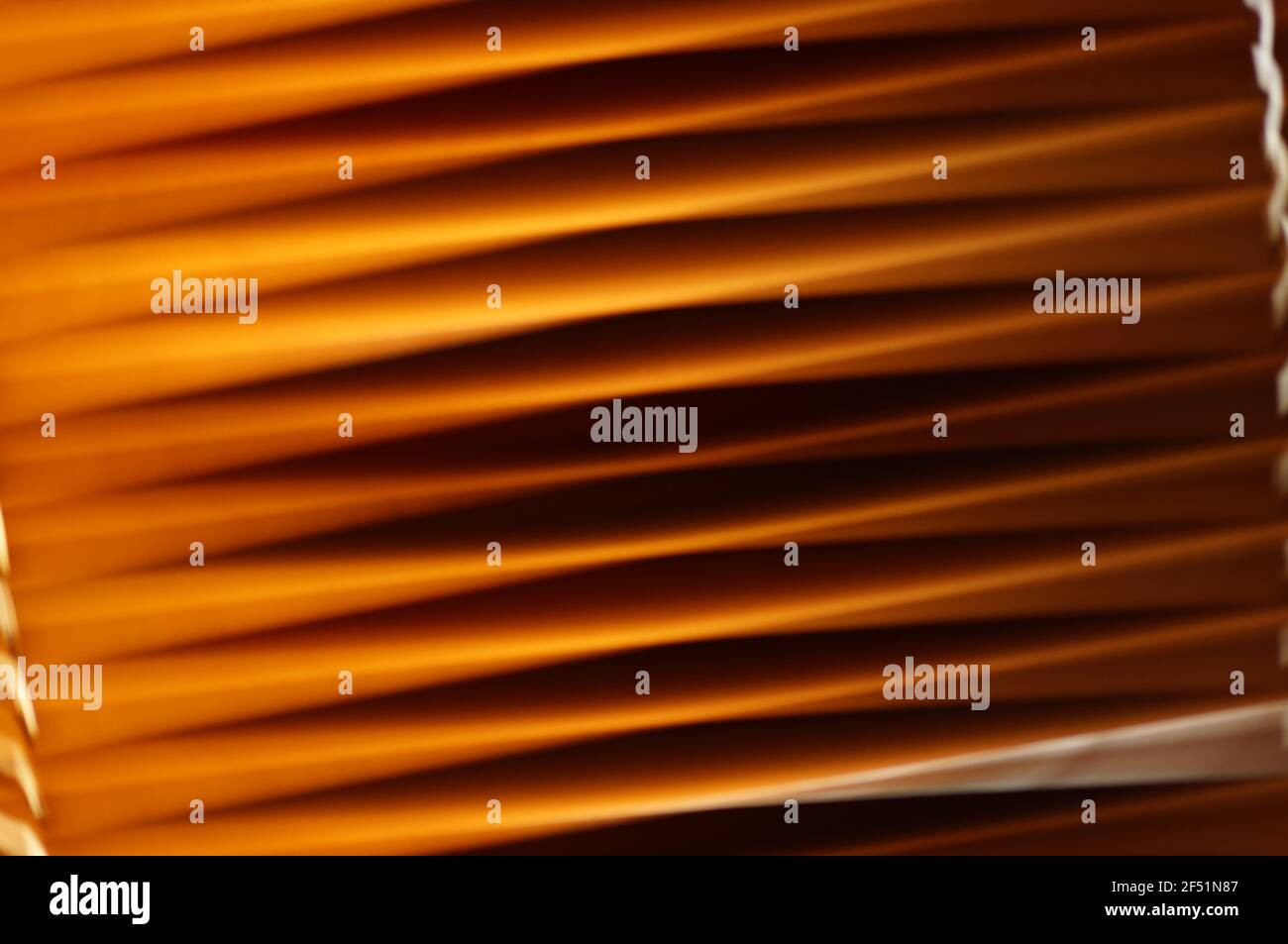 Holzjalousien im Fenster - schräge Aussicht. Fenstervorhänge aus Naturholz. Schräge orangefarbene Linien. Jalousien in Nahaufnahme. Stockfoto