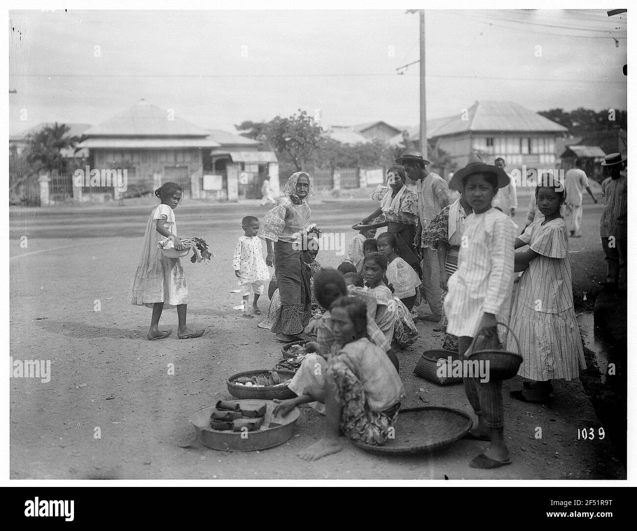 Manila. Straßenhändler, vor allem Kinder, sitzen am Straßenrand und bieten ihre Waren aus runden Körben Feil Stockfoto