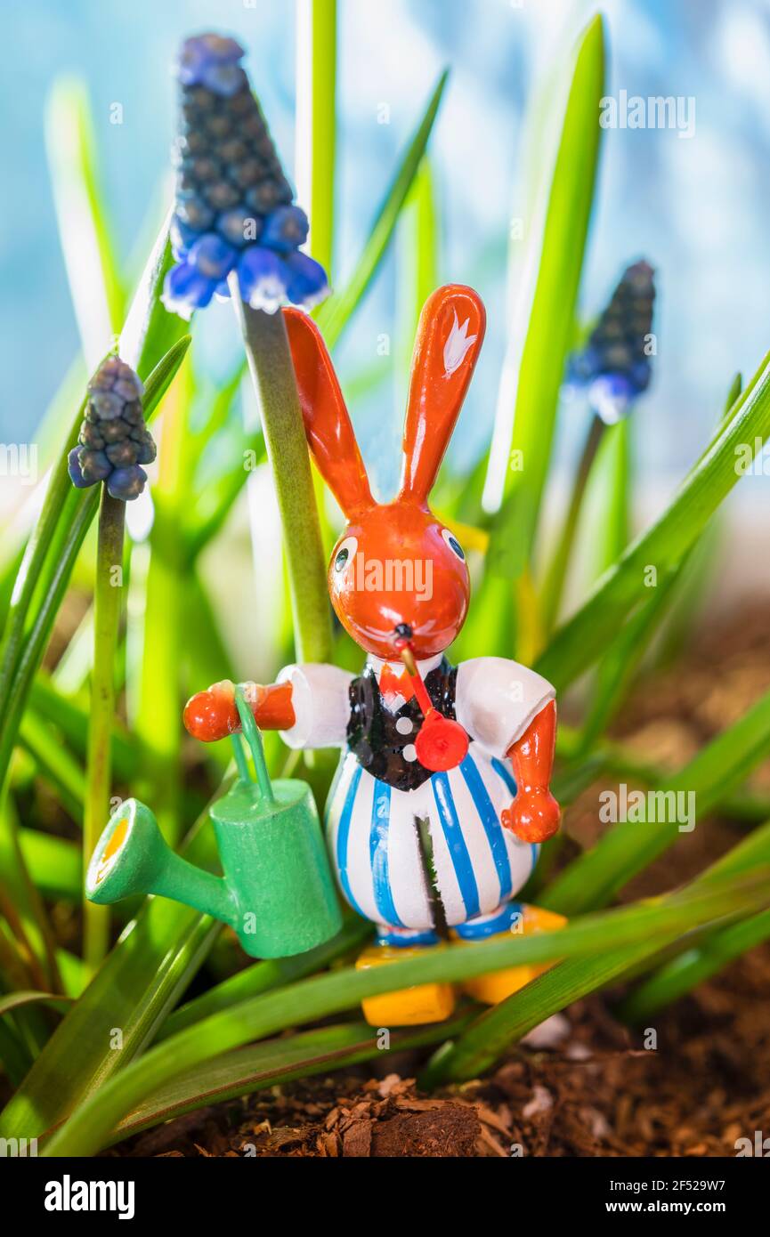 Kleines Kaninchen aus Holz in Kleidung in einem Garten Stockfoto