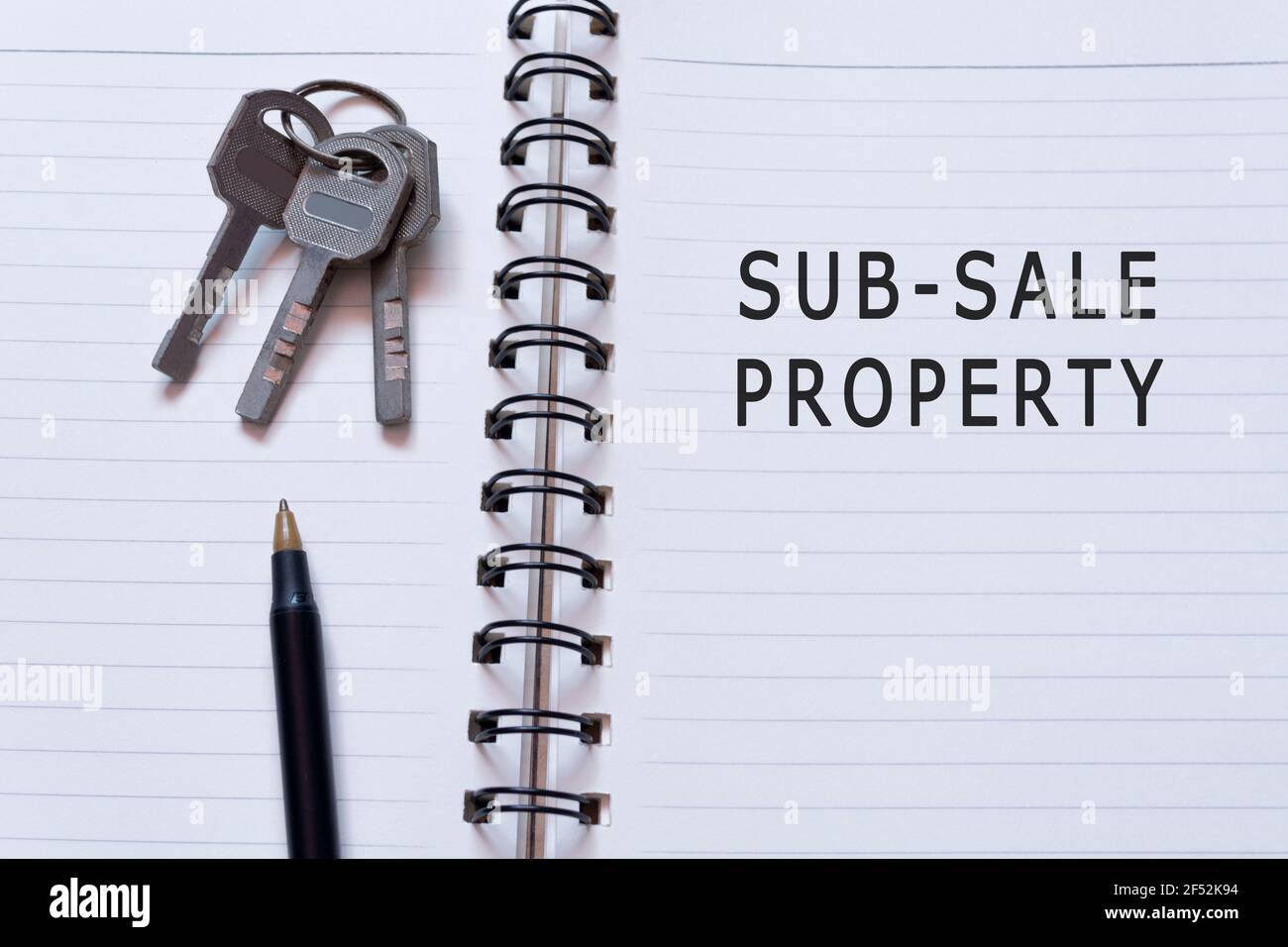 Text auf Notizbuch mit Hausschlüssel und Stift - Unterverkauf Eigentum Stockfoto