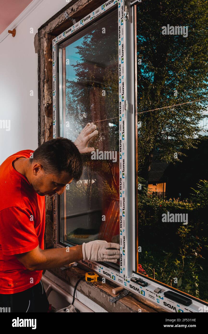 Dolyna, Ukraine 31. Juli 2020: Ein Mitarbeiter installiert ein Fenster im Haus, Installation eines Kunststofffensters, wds-Fenster, Energiesparfenster.neu Stockfoto