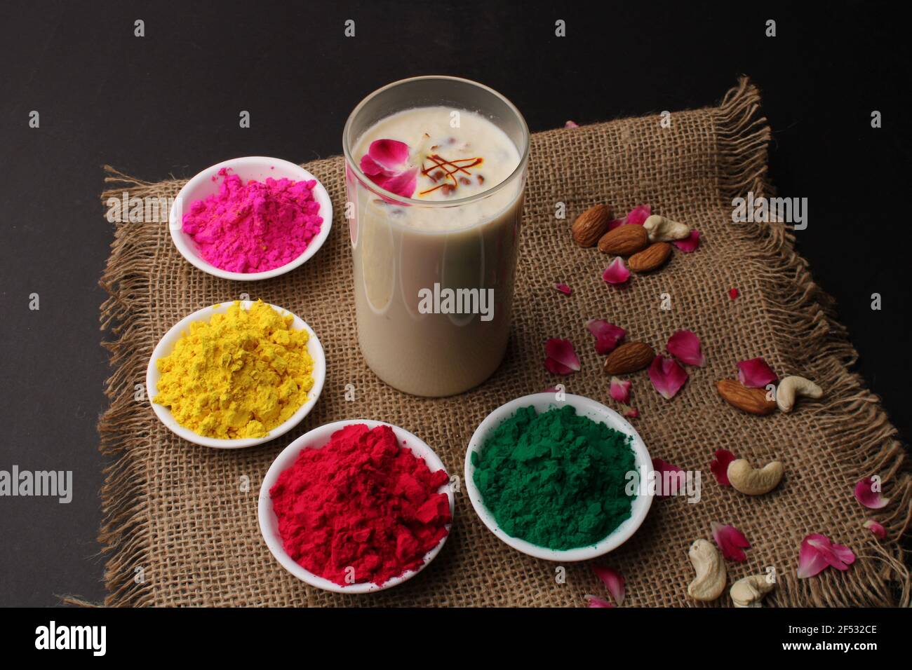 Indian Festival Holi Konzept - traditionelle indische Getränk Thandai Sardai Milch Festival Essen, mit Nüssen und Farbe in Schüssel. Stockfoto