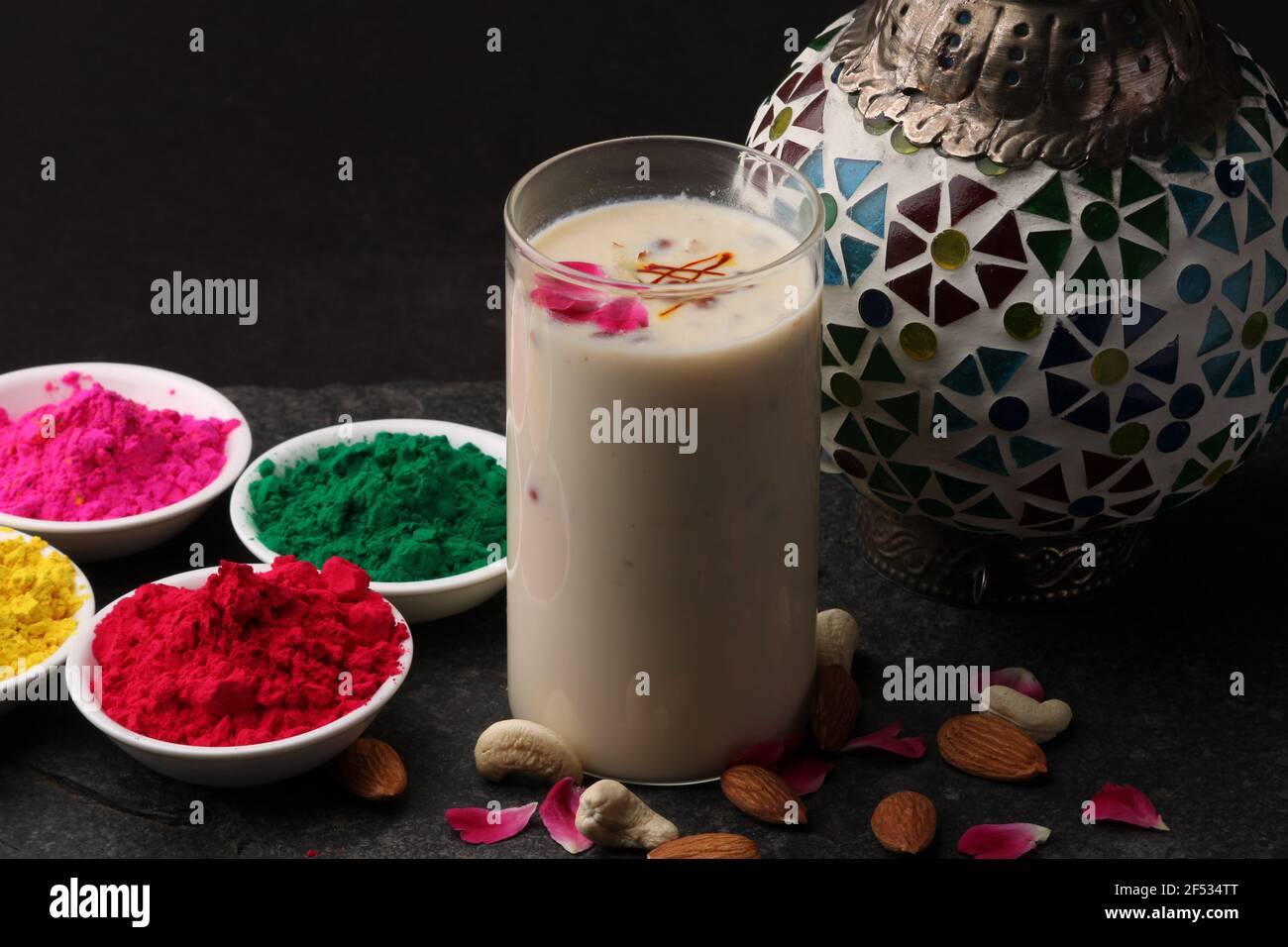 Indian Festival Holi Konzept - traditionelle indische Getränk Thandai Sardai Milch Festival Essen, mit Nüssen und Farbe in Schüssel. Stockfoto