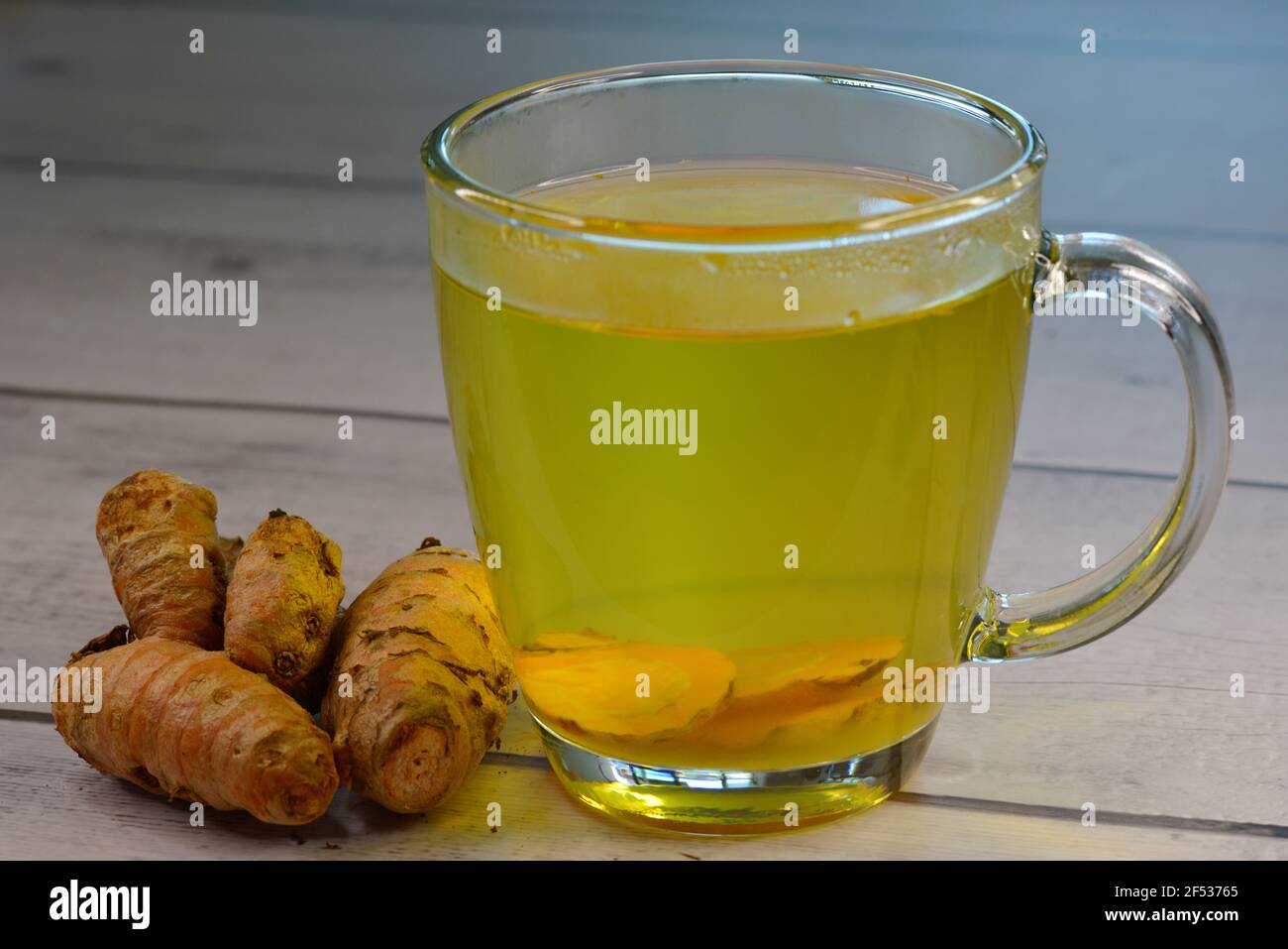 Tee aus geschnittener Kurkumenwurzel, mit Vollrhizom gebraut. Die Wurzeln stammen aus dem indischen Subkontinent und werden in der Küche und ayurvedischen Medizin verwendet. Stockfoto