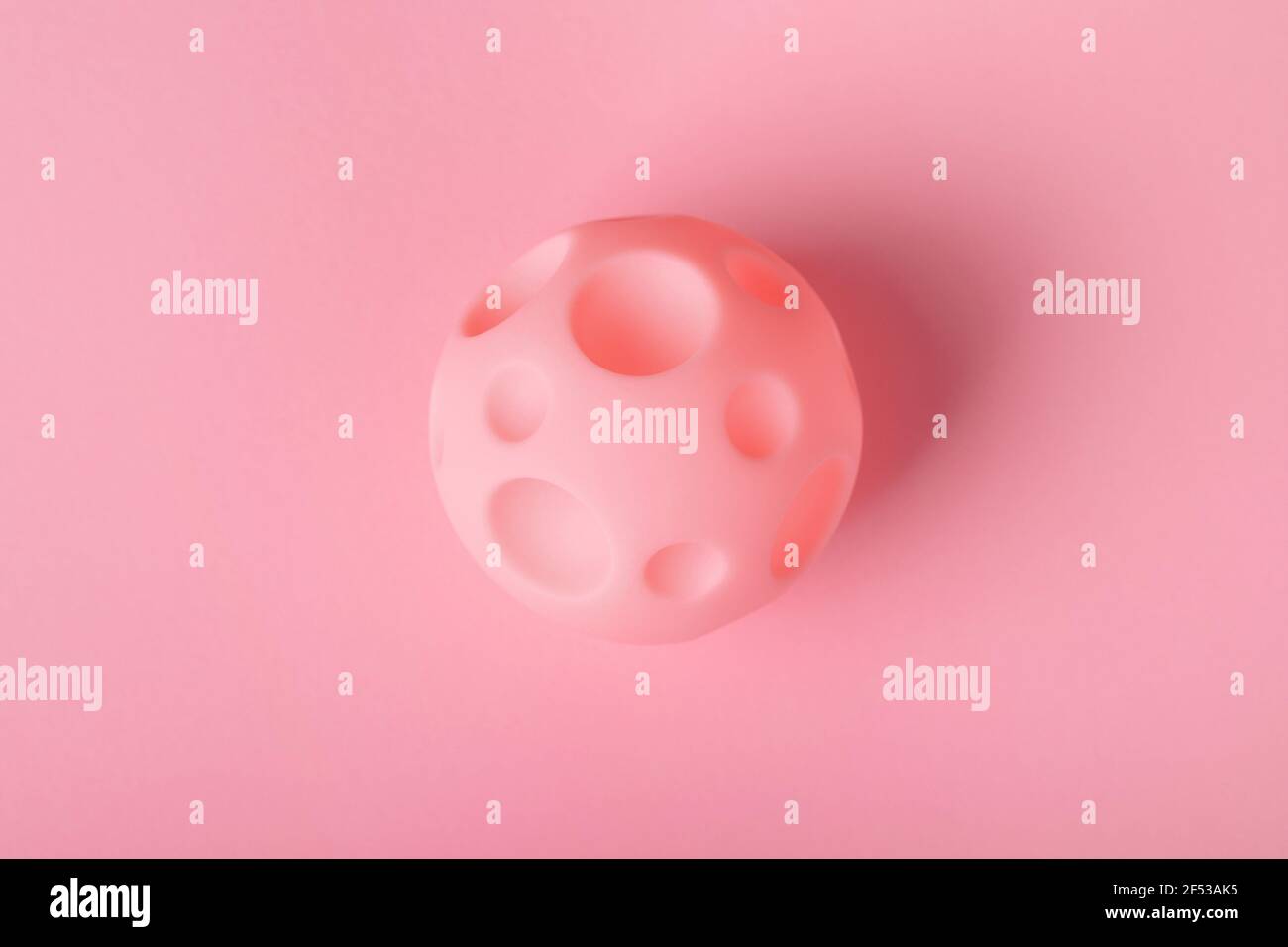 Spielzeugball mit Krater auf einem hellen Hintergrund, das Konzept der Eroberung des Weltraums und neue Planeten Stockfoto