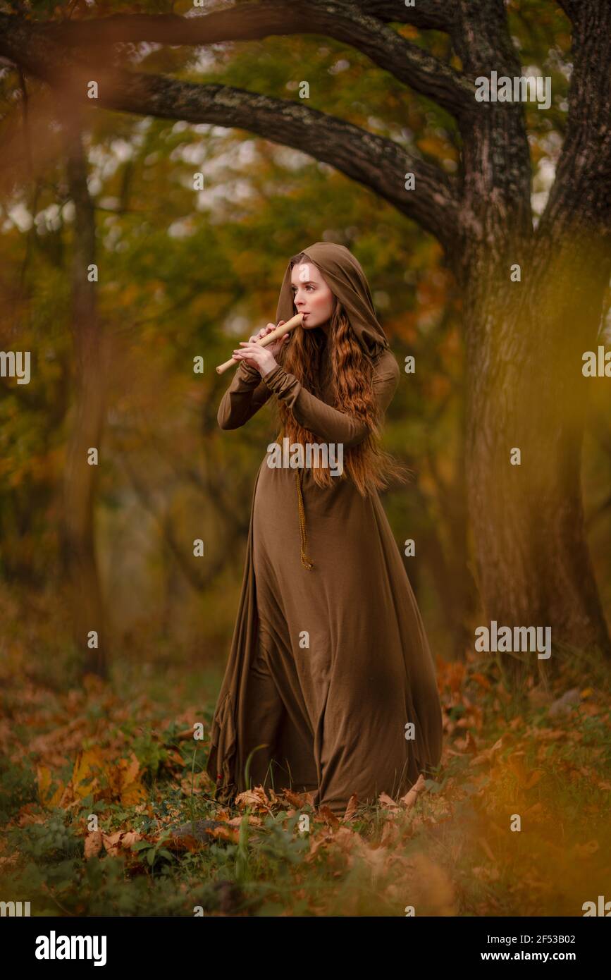 Rotschopf Frau im Kleid zu Fuß in Fantasy Märchen Wald Stockfoto