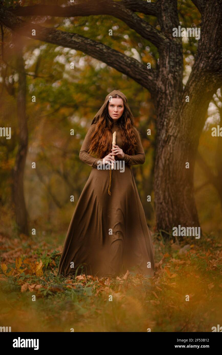 Rotschopf Frau im Kleid zu Fuß in Fantasy Märchen Wald Stockfoto