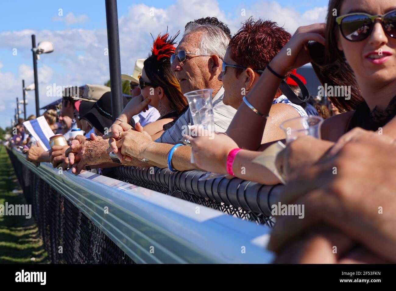 Zuschauer an der Bahn beobachten das Rennen bis zum Ziel bei einem Landpferderennen in Queensland, Australien Stockfoto