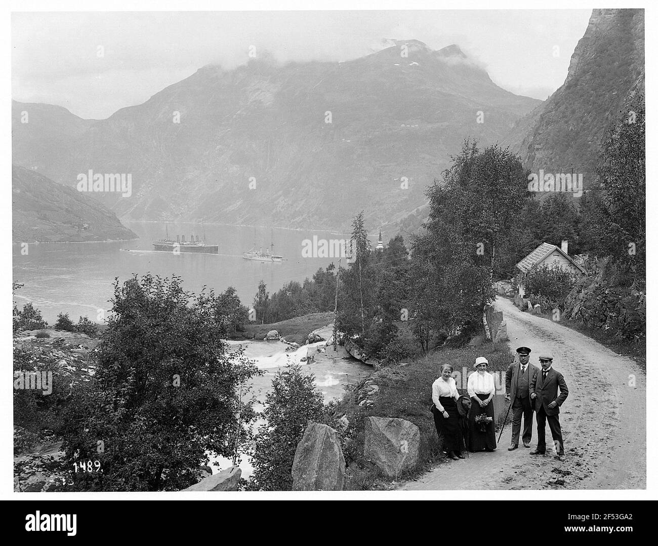 Merok / Norwegen: Im Geirangerfjord. Touristen posieren am Fuß Rand am Ufer des Geirangerfjord für Kamera Stockfoto