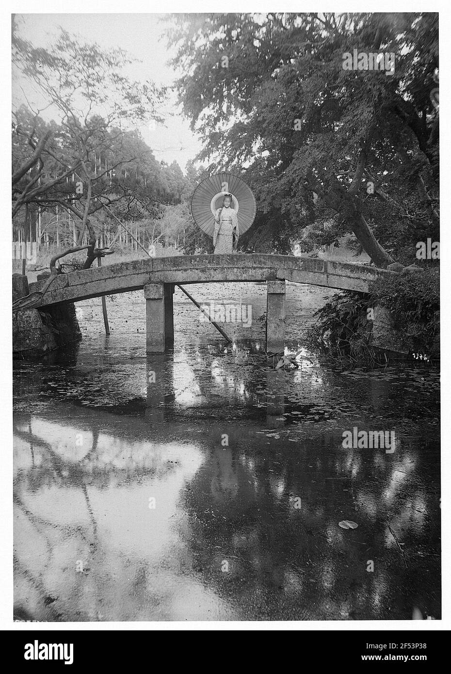 Japan. Japanische Frau mit geklatschter Leinwand steht auf einer massiven Bogenbrücke Stockfoto