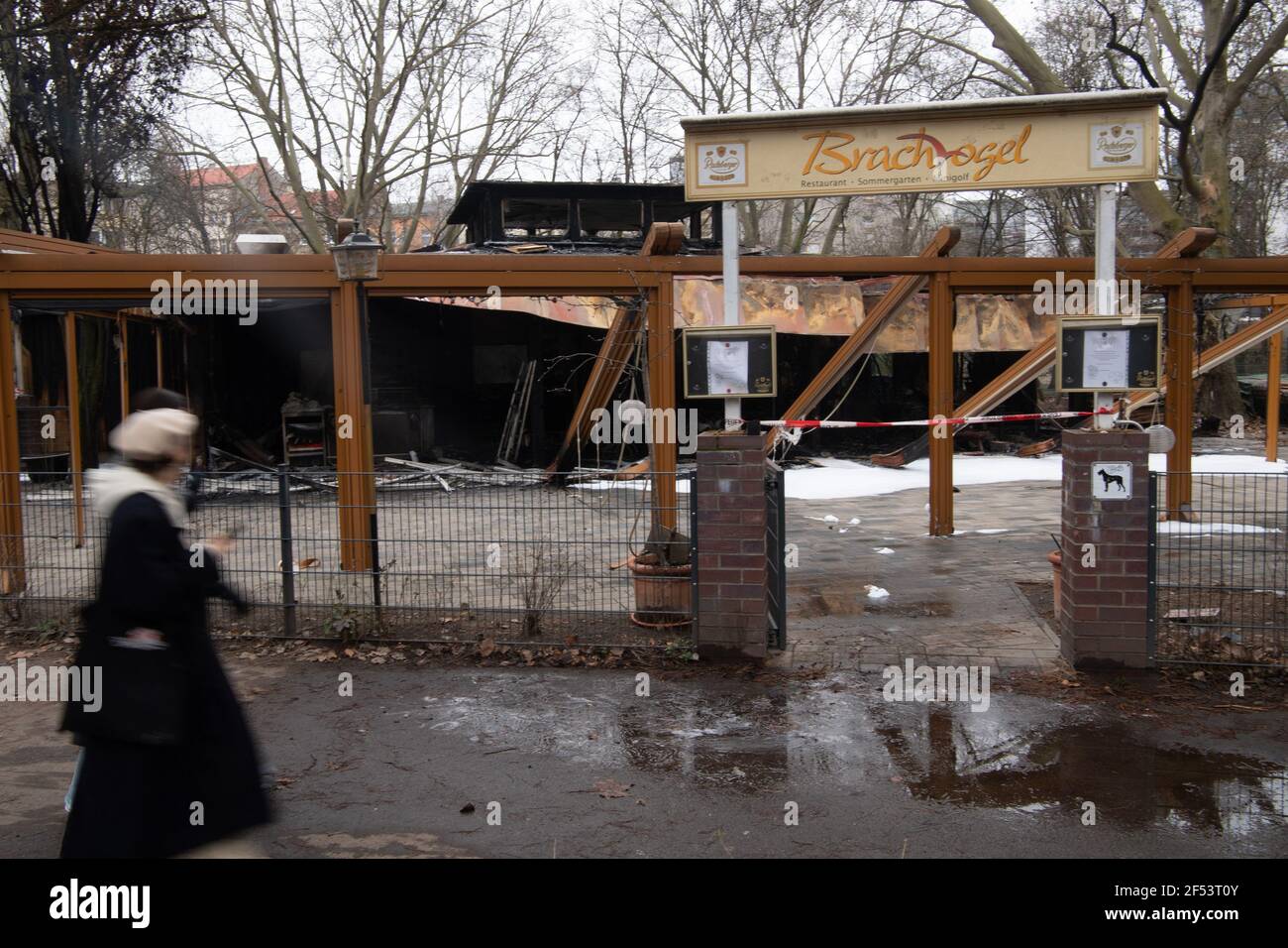 Berlin, Deutschland. März 2021, 24th. Wanderer kommen am ausgebrannten Restaurant 'Brachvogel' am Landwehrkanal in Kreuzberg vorbei. Das Restaurant brannte in der Nacht auf Mittwoch ab. Als die Feuerwehr am Carl-Herz-Ufer eintraf, hatte sich das Feuer vom Dach bereits auf das gesamte 200 Quadratmeter große Ausflugsrestaurant ausgebreitet, wie die Feuerwehr in der Nacht twitterte. Quelle: Paul Zinken/dpa-Zentralbild/dpa/Alamy Live News Stockfoto