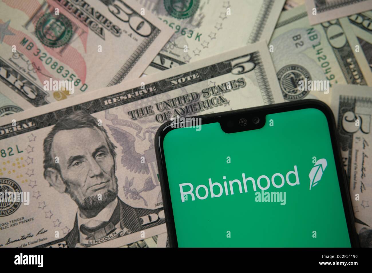 Robinhood App-Logo auf dem Smartphone auf US-Dollar-Banknoten gesehen. Robinhood ist eine Investitions- und Trading-App für Aktien, Aktien und Kryptowährungen. Staffo Stockfoto