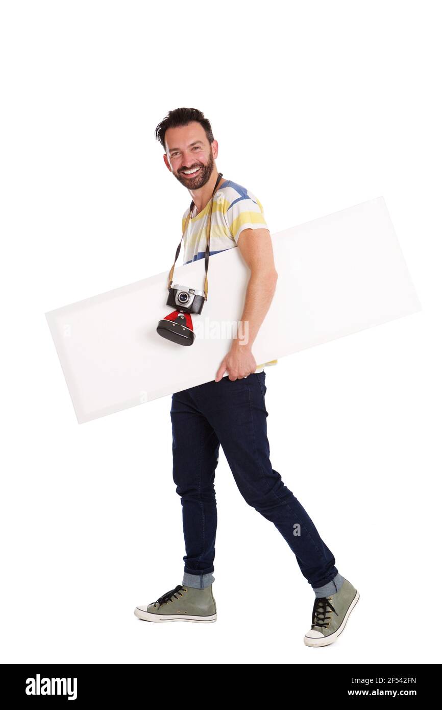 Ganzkörperportrait des männlichen Fotografen mit leerem Seufzer-Brett Gehen über weißen Hintergrund Stockfoto