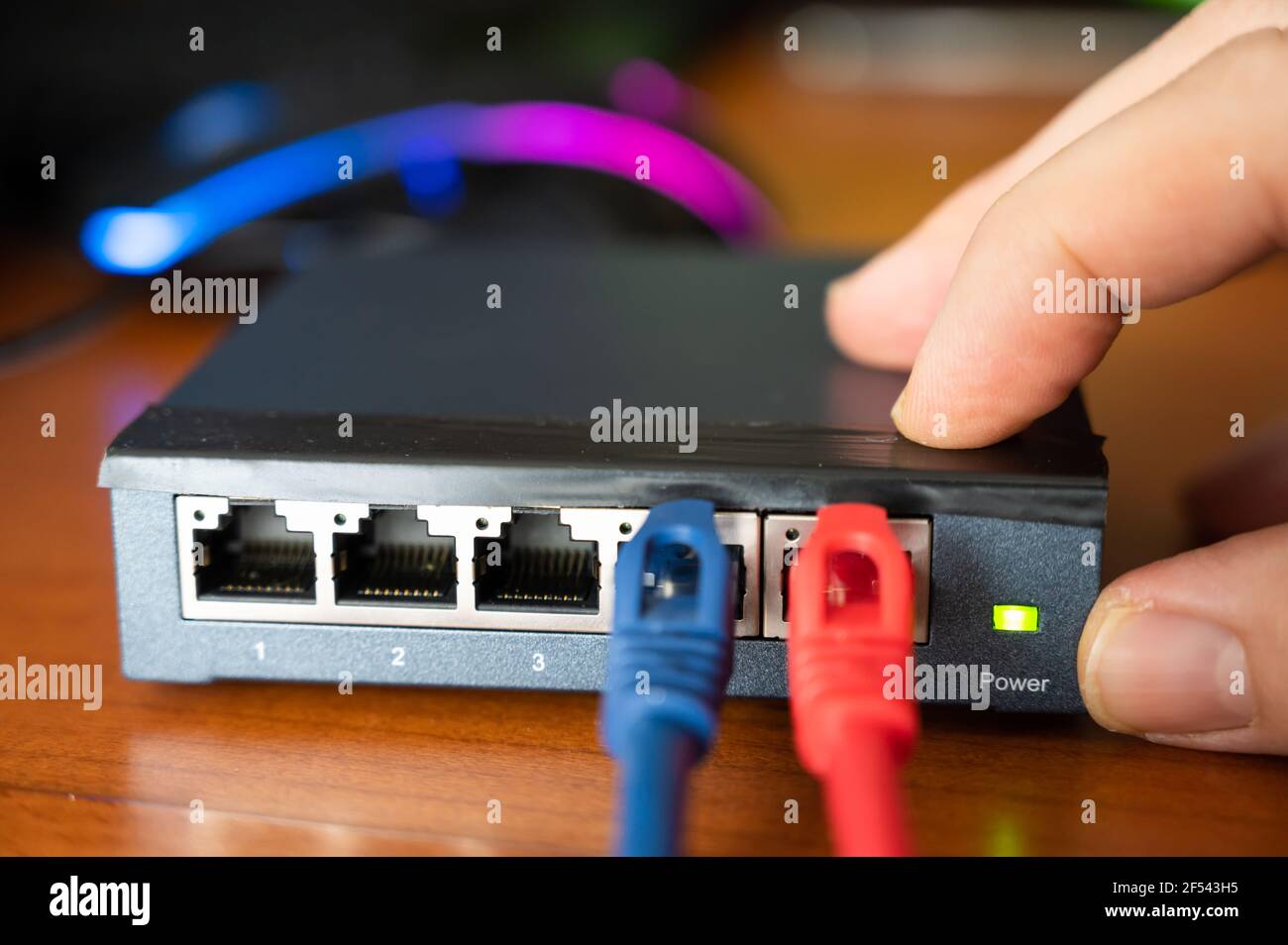 Nahaufnahme eines Routers: Neben dem blauen Ethernet-Kabel ist ein rotes Kabel angeschlossen. Konzept der Verkabelung, Internet-Netzwerk, Arbeiten mit Internet-Netzwerk Stockfoto