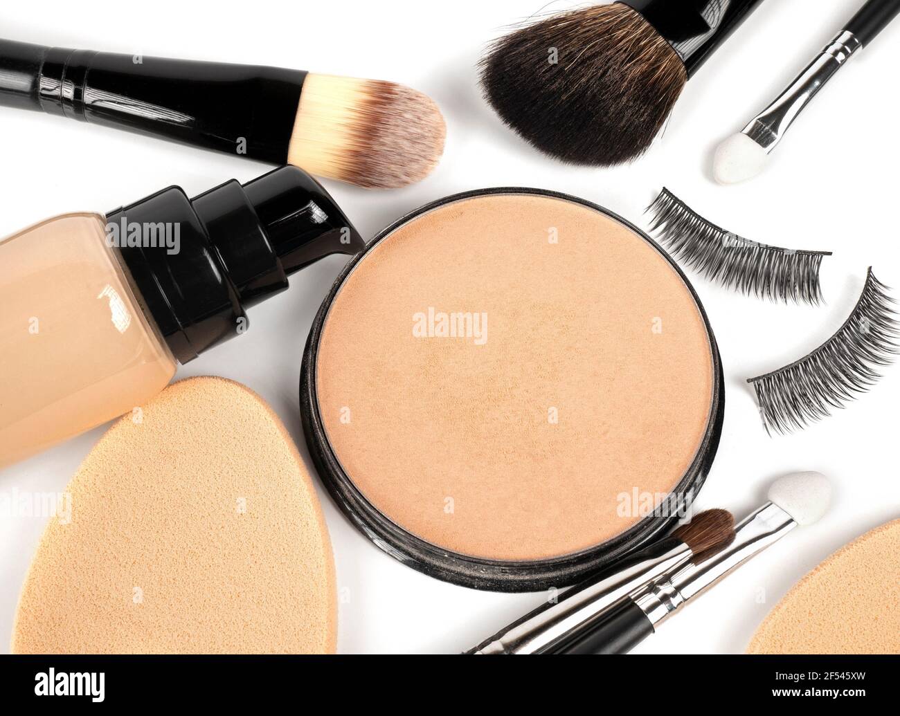 Foundation, Pulver, Concealer, Make-up Pinsel, Make-up Schwämme, Falsche Wimpern auf weißem Hintergrund Stockfoto