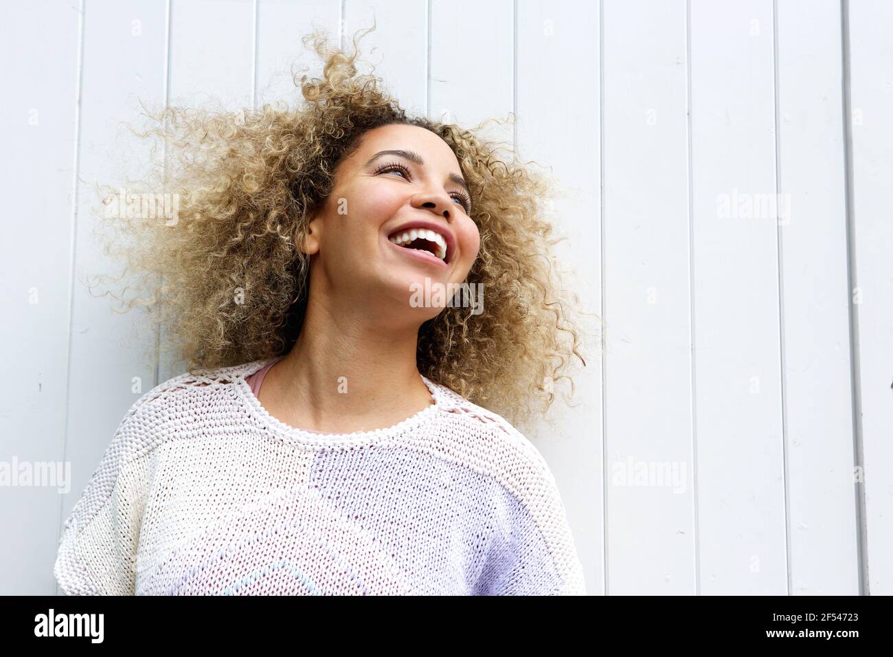 Nahaufnahme Porträt einer lächelnden jungen Frau mit Haaren weht Bei Wind Stockfoto