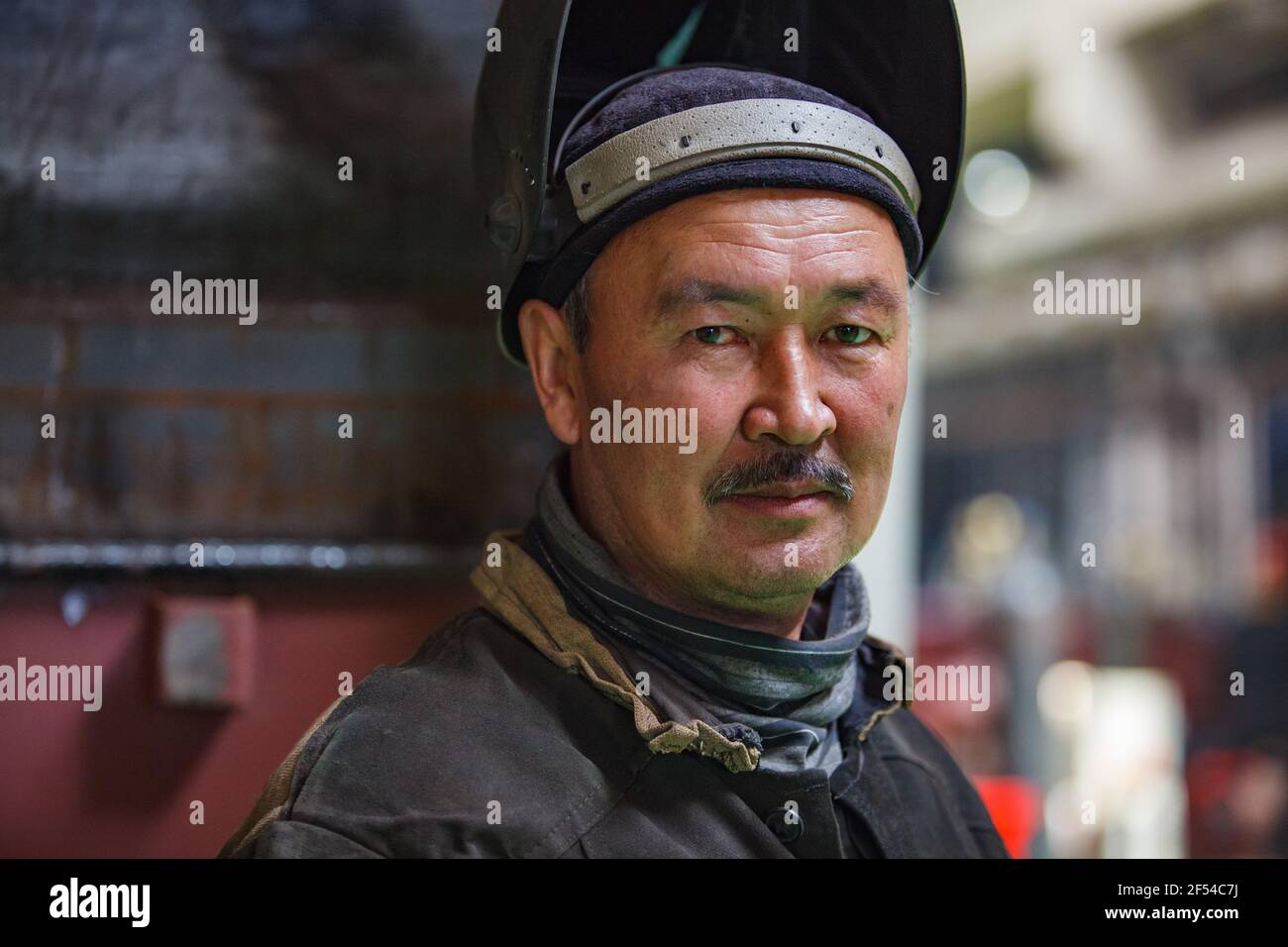 Ekibastuz, Region Pavlodar, Kasachstan - 28. Mai 2012: Wagenbauwerk. Porträt eines asiatischen Schweißerarbeiters mit Schutzmaske. Stockfoto