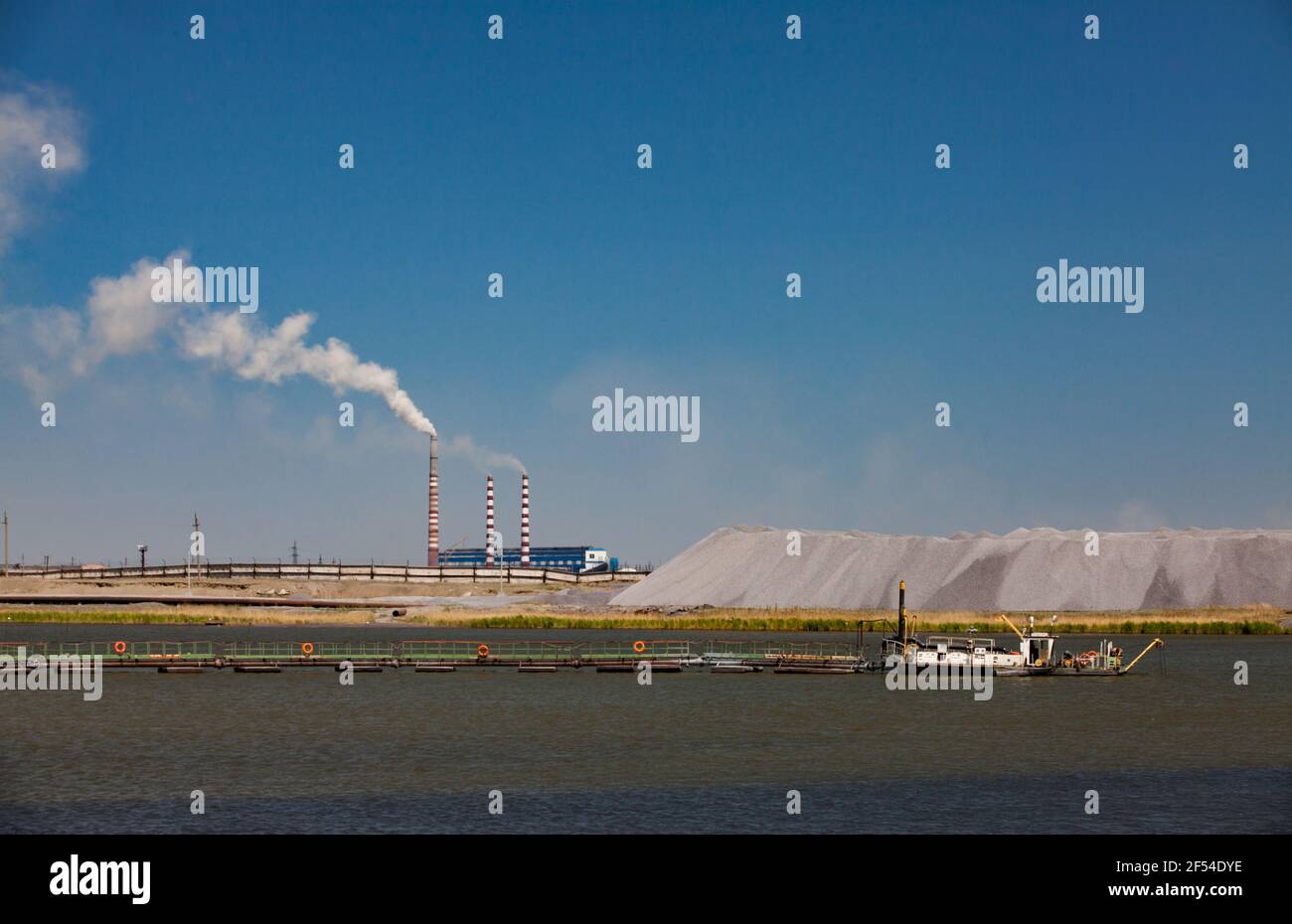 Wasserlagerung Der Metallurgie Anlage Weisses Boot Und Pier Im Vordergrund Und Abgestreiften Fabrikschornstein Des Kraftwerks Mit Weissem Rauch Blauer Himmel Stockfotografie Alamy