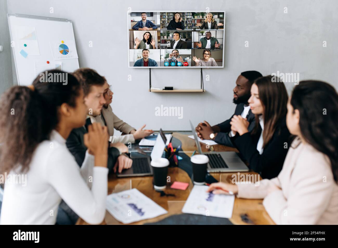 Erfolgreiche multiethnische Kollegen, die in modernen Büros verhandeln. Geschäftsleute auf Online-Konferenz diskutieren Arbeitsfragen, Entwicklung neuer Strategie für Unternehmen, Online-Briefing Stockfoto