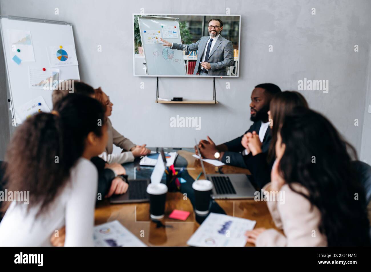 Multirassische Gruppe von Geschäftsleuten sprechen über neue Strategie für Unternehmen, mit einem Brainstorming, Online-Briefing mit Direktor. Erfolgreiche Mitarbeiter diskutieren Ideen und Pläne, Partnerschaftskonzept Stockfoto